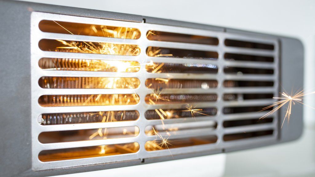 Stock image shows sparks inside an electric fan heater