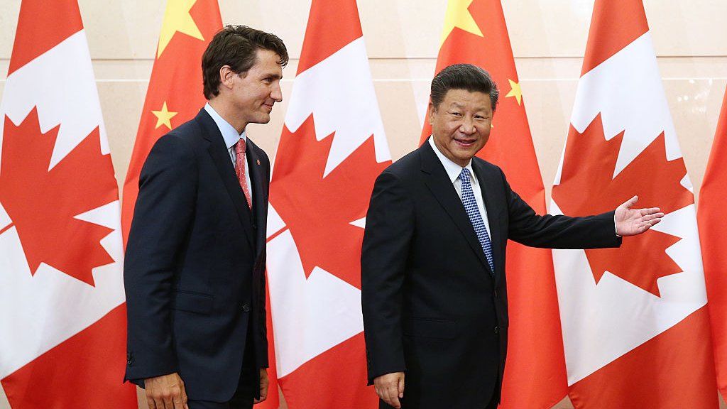 Photo of Justin Trudeau and Xi Jinping in front of a backdrop of Chinese and Canadian flags