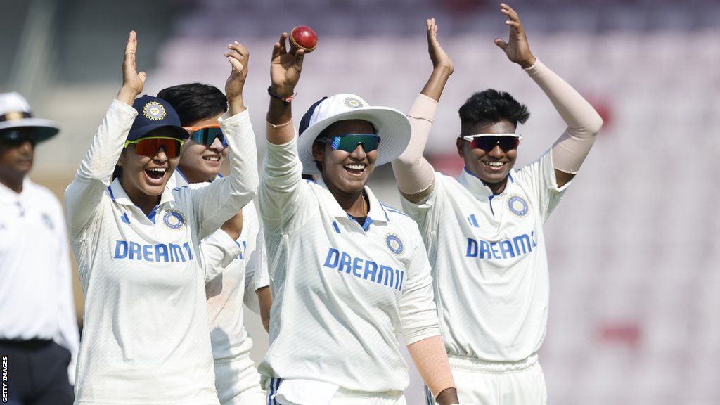 India spinner Deepti Sharma (middle) raises the ball after taking five wickets against England, and is clapped by her team-mates