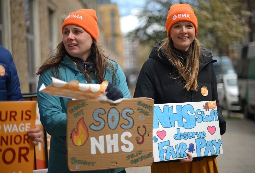 People hold placards on a picket line outside Great Ormond Street Children's Hospital in London