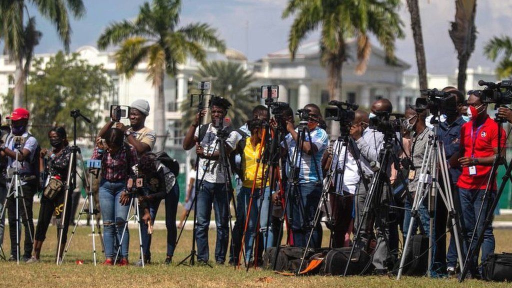 Members of the media cover a mass in memory of the victims of the 2010 earthquake, in Port-au-Prince, January 12, 2022
