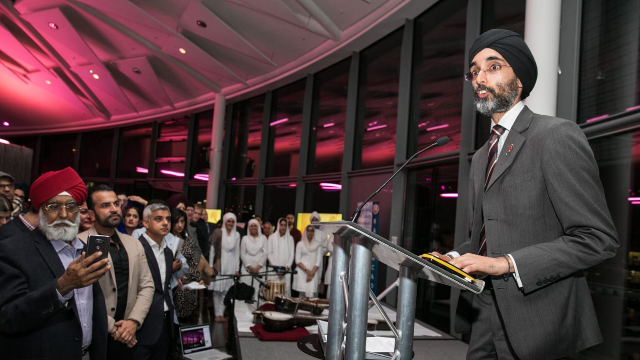 Jasvir addresses meeting (Mayor of London Sadiq Khan stands in front row of audience)