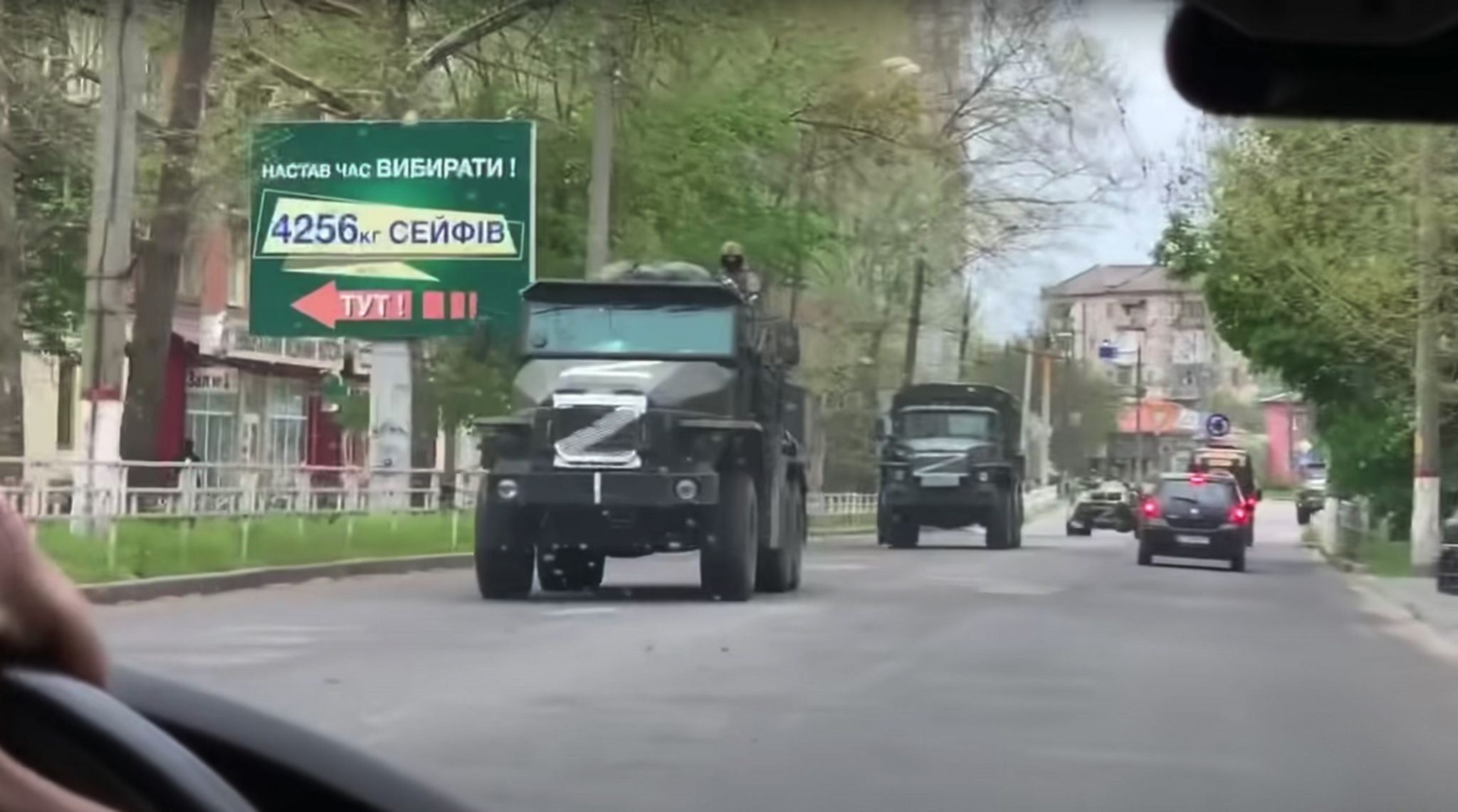 Large Russian Trucks with white Z painted on them drive down a street