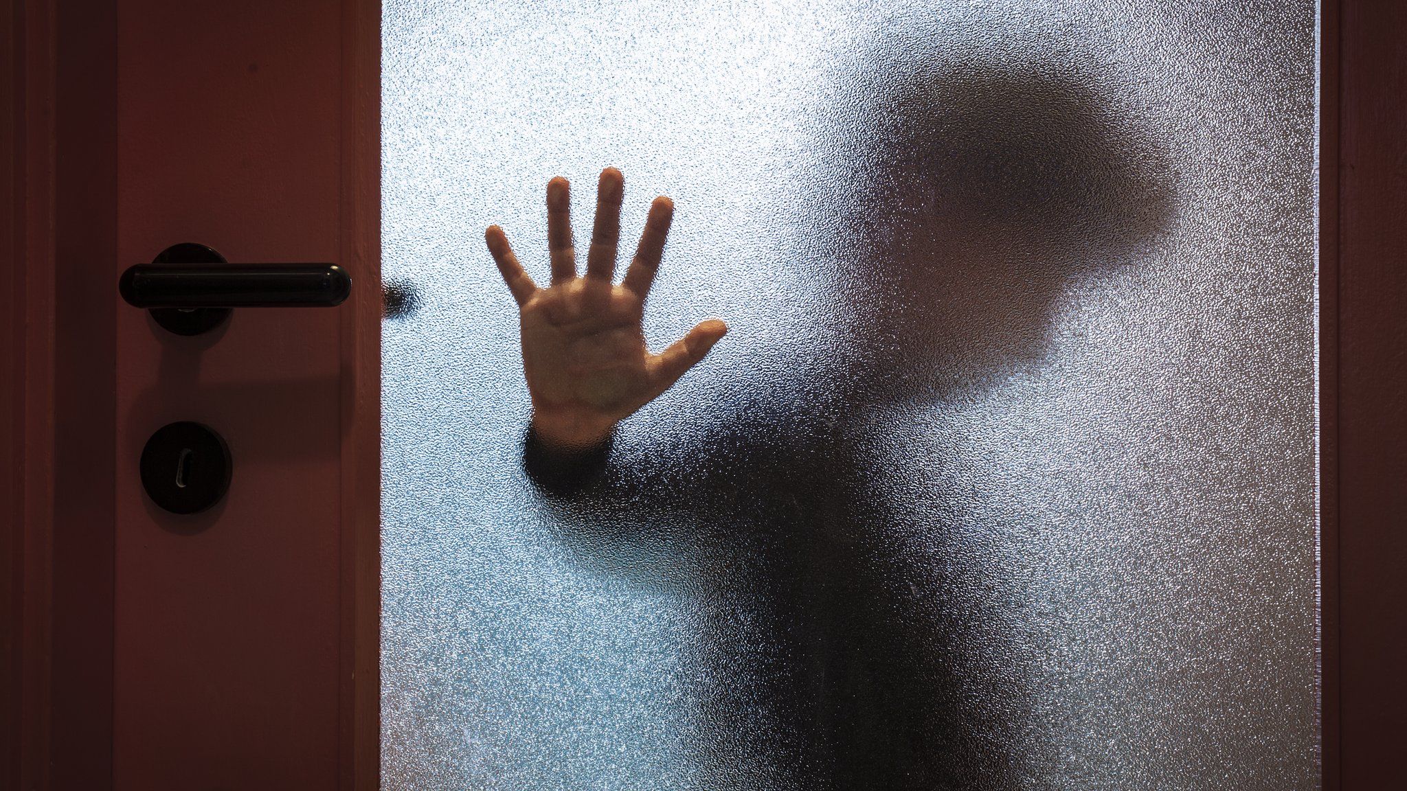 Blurred picture of child's hand against a door