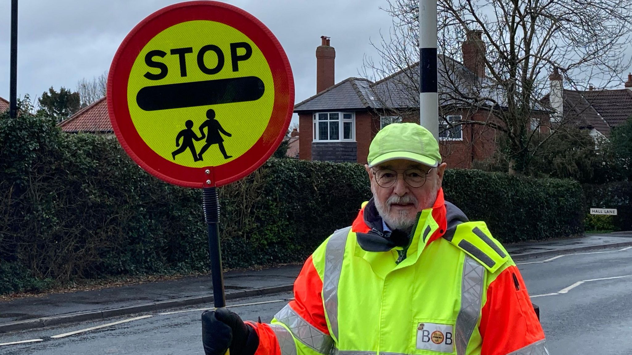 School crossing patrol officer Bob O'Neill stood with his lollipop at the side of the road