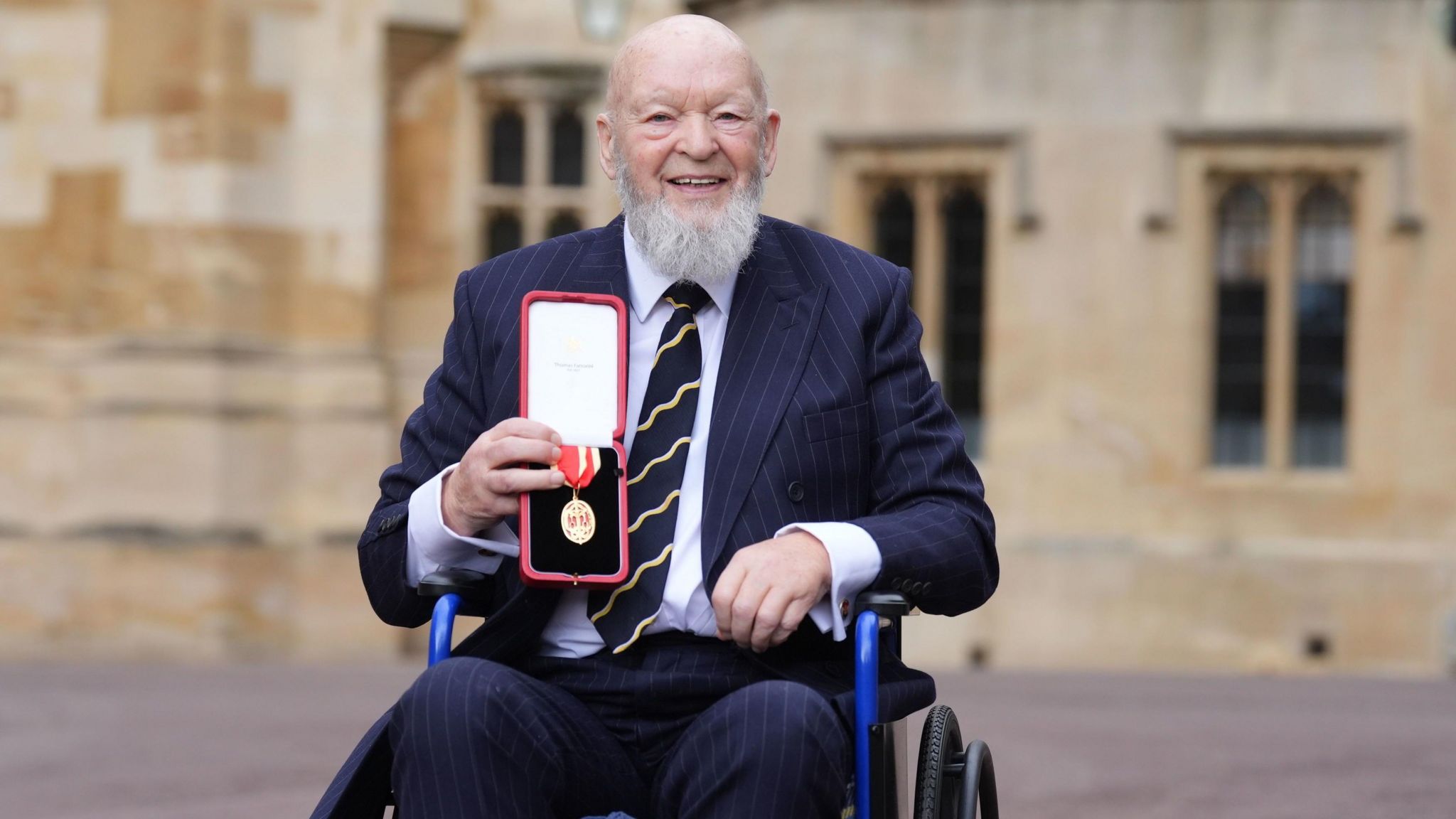 Michael Eavis with the medal awarded to him for his knighthood