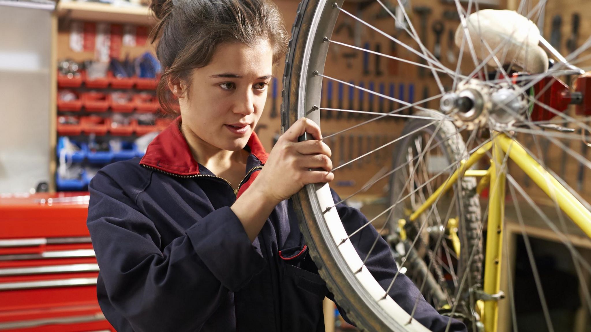 A young woman fixing a bike