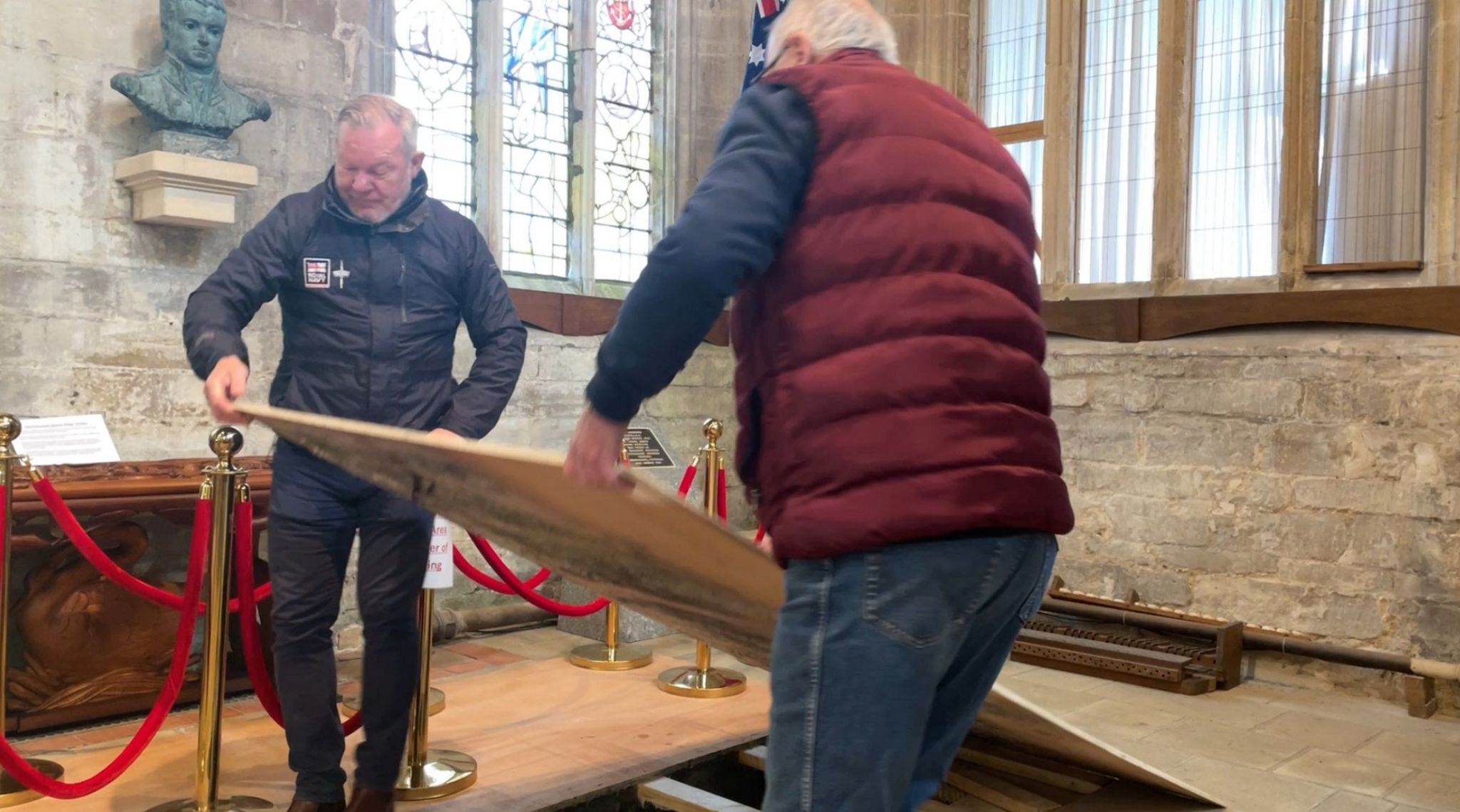 two men lowering wooden boards
