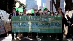 Сторонники шести истцов на митинге в их поддержку перед зданием суда в Токио