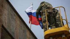 Российские солдаты водружают российский флаг над зданием захваченной администрации Светлодара