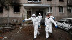 Сотрудники МЧС Украины выносят тело из дома