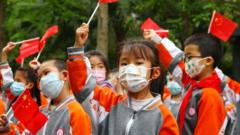 Дети в марлевых повязках с китайскими флагами