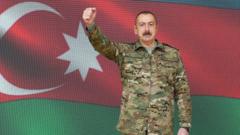 Алиев в военной форме на фоне азербайджанского флага грозит рукой в камеру