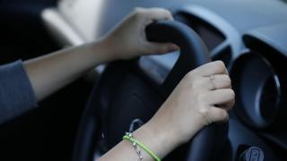 Person holding a driving wheel in the car