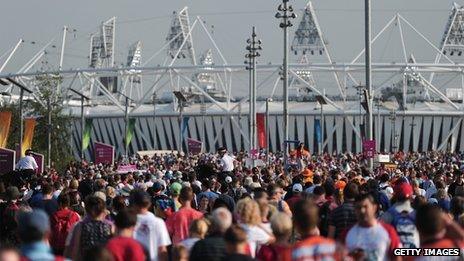 Spectators walk to and from the Olympic stadium