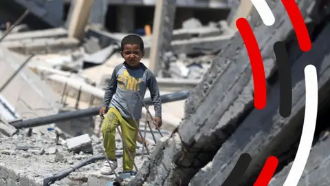 A Palestinian child walking in rubble in Khan Yunis