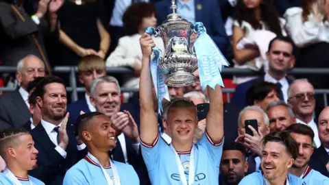 Erling Haaland holds the the FA Cup aloft
