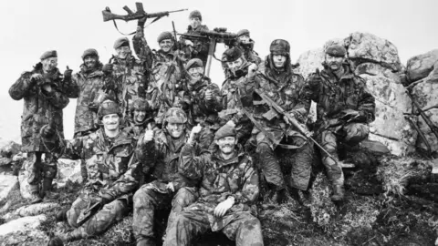 7 Platoon, G Company, 2nd Battalion Scots Guards on Mount Tumbledown celebrate the news of the Argentine surrender