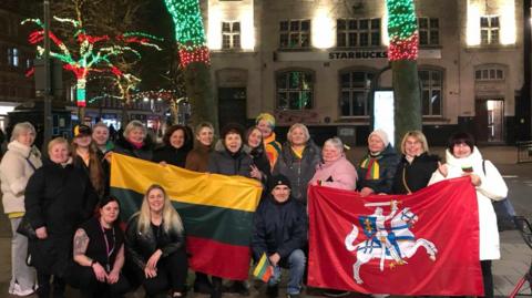 People holding the Lithuanian flag in Peterborough City Centre 
