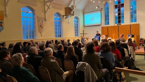 A number of people meeting in a church