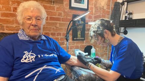 Winifred Pinner getting a tattoo from Gemma