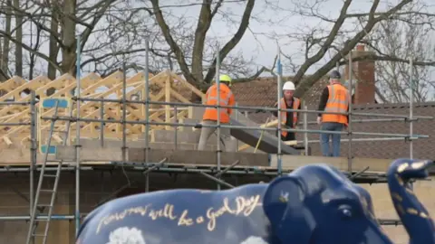 Workmen begin dismantling an unauthorised spa pool block at Captain Tom's daughter's home.