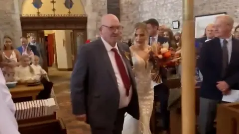 Watch the moment a paralysed man walks his daughter down the aisle.