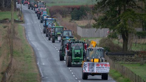 Protesting tractors being driven along pylon route 