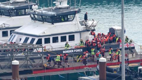 A group of people being brought into Dover port