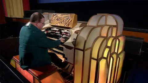 A man playing the Compton cinema pipe organs