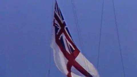 White ensign flag being lowered at Chatham Dockyard