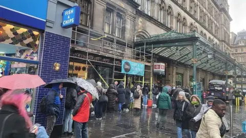 People queue outside Glasgow Central Station.
