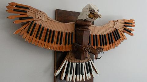 An eagle made from piano keys hanging on a wall
