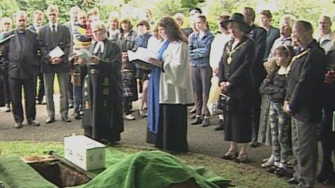 Mourners and a vicar at the burial of baby Callum 