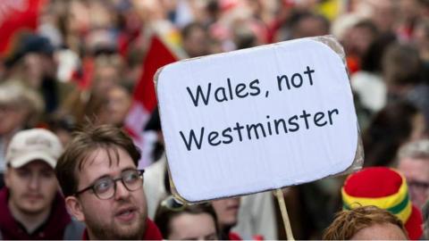 Protester holding a sign saying "Wales, not Westminster"