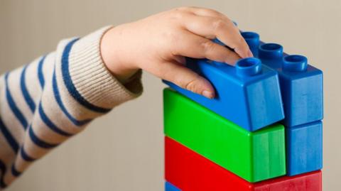 Child's hand with building blocks