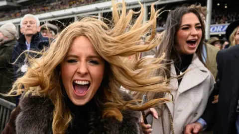 Race-goers celebrate Ballyburn's win at day two of the Cheltenham Festival