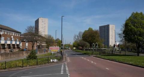 A street with two high-rise flats in the distance