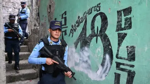 Members of the National Police patrol in Colonia Divanna, Barrio 18 gang territory, in Tegucigalpa on March 17, 2023