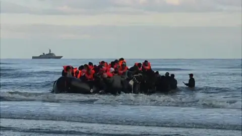 People boarding a migrant boat in Calais, France
