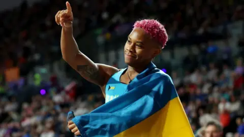 Devynne Charlton of Team Bahamas gestures after winning and setting a new world record