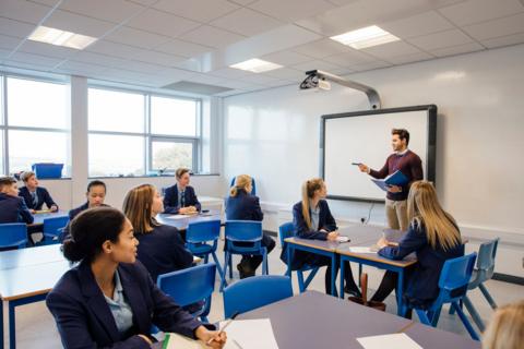 A class of pupils learning from a teacher in a secondary school classroom