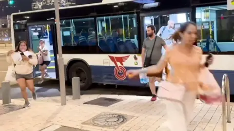 People running from a bus in Tel Aviv