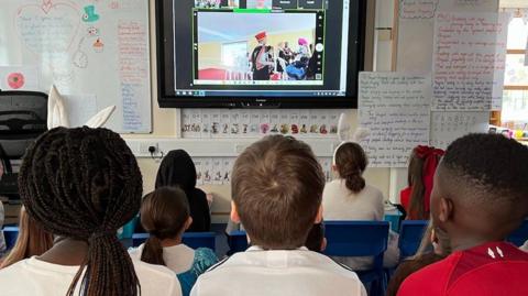School children watching a video link