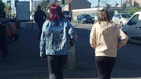 Two girls walking across the road
