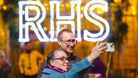 Couple take selfie in front of RHS sign