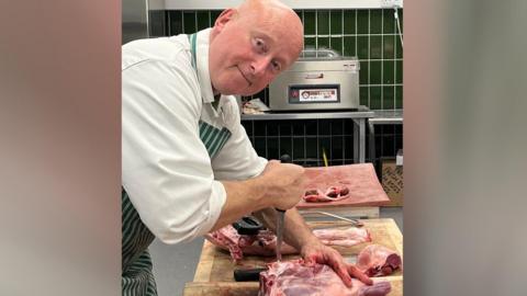 Phil chopping a piece of lamb leg 