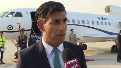 Prime Minister Rishi Sunak speaking in front of a jet plane in Cairo