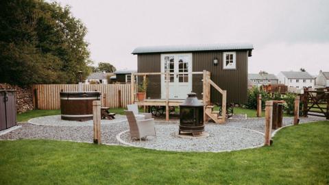 A caravan with a hot tub outside it