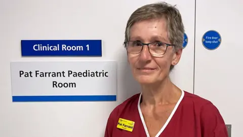 King's College Hospital sonographer Pat Farrant in front her door in the new ultrasound unit